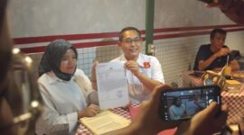 Dokter Silvi Priyani bersama kuasa hukumnya dari KANNI, Ruswan Efendi, menunjukkan bukti laporan polisi terkait dugaan penggelapan dana proyek food tray MBG di Polres Kota Sukabumi, Jumat (30/5/2025).