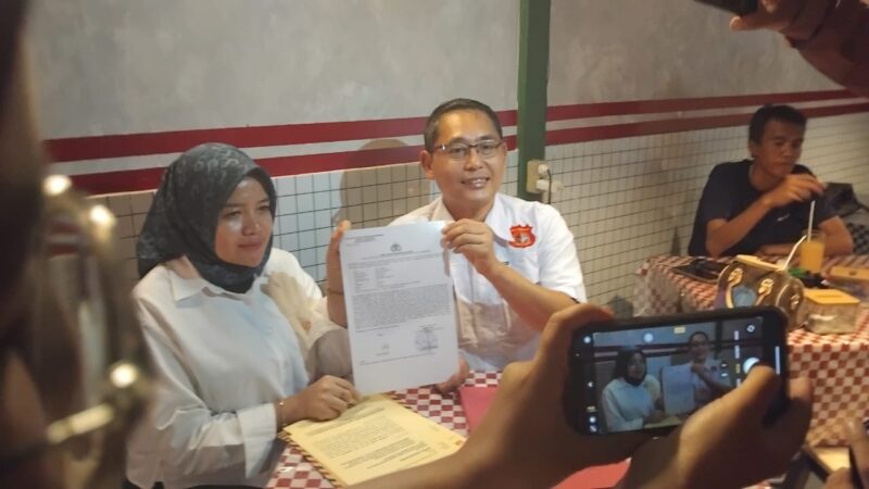 Dokter Silvi Priyani bersama kuasa hukumnya dari KANNI, Ruswan Efendi, menunjukkan bukti laporan polisi terkait dugaan penggelapan dana proyek food tray MBG di Polres Kota Sukabumi, Jumat (30/5/2025).