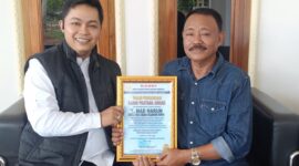 Ketua KANNI Kabupaten Bogor, Haidy Arsyad (kiri), menyerahkan Piagam Penghargaan KANNI Pratama Award kepada H. Mad Harun, Kepala Desa Cibodas, atas dedikasinya membangun masyarakat sadar hukum, Sabtu (24/5/2025).