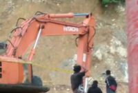 Petugas memasang garis polisi pada alat berat di lokasi tambang emas ilegal milik Ci Dede di Ratatotok, Mitra, Sulawesi Utara, Selasa (8/7/2025).