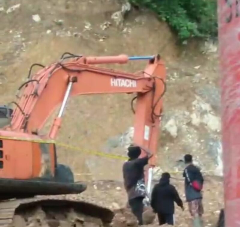 Petugas memasang garis polisi pada alat berat di lokasi tambang emas ilegal milik Ci Dede di Ratatotok, Mitra, Sulawesi Utara, Selasa (8/7/2025).